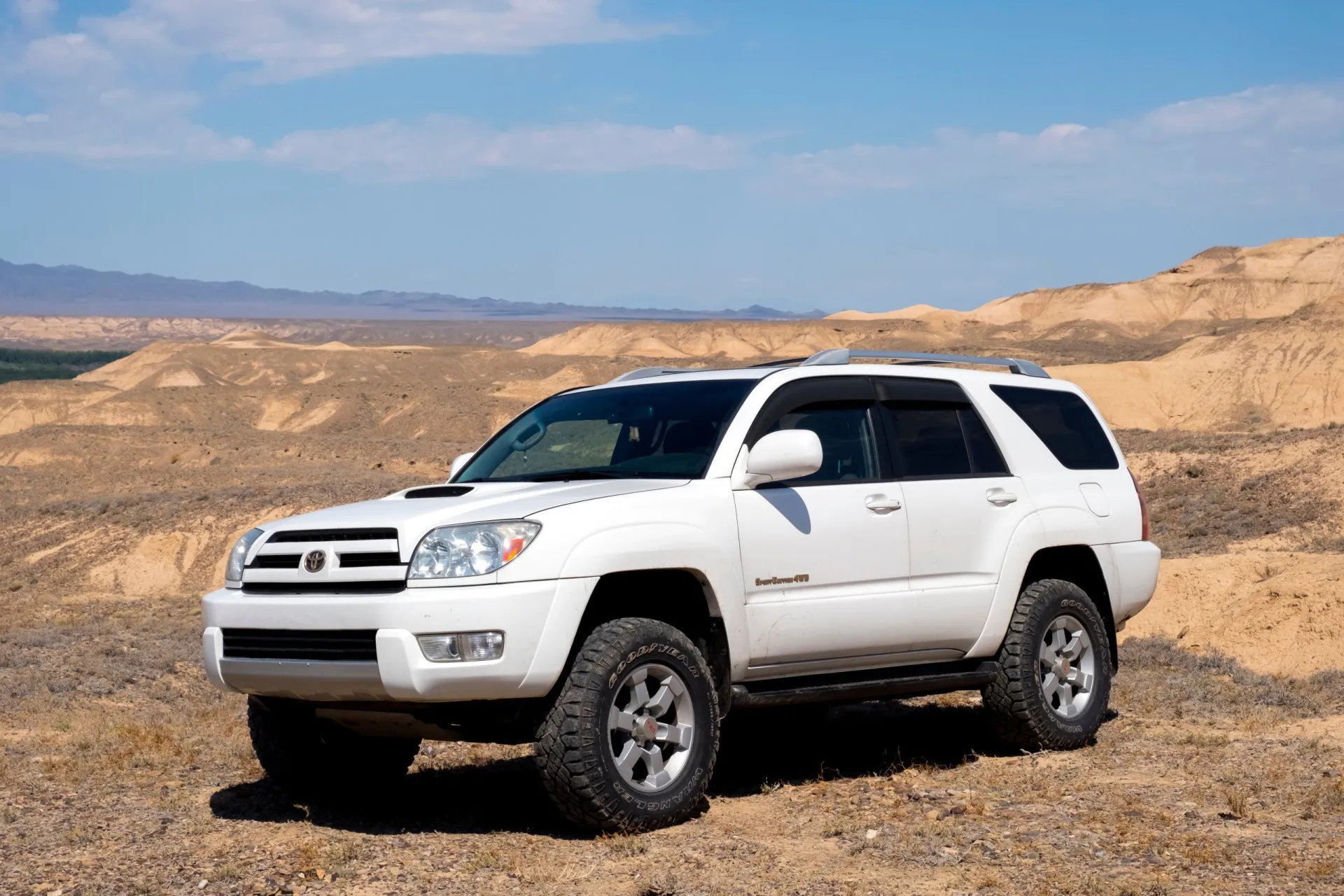 2005 Toyota 4runner SUV in desert canyon with blue sky.