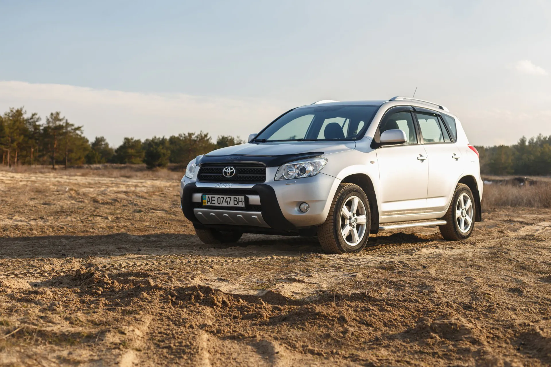 Toyota Rav4 2006 gray color among the sand near the forest, open space on sunset