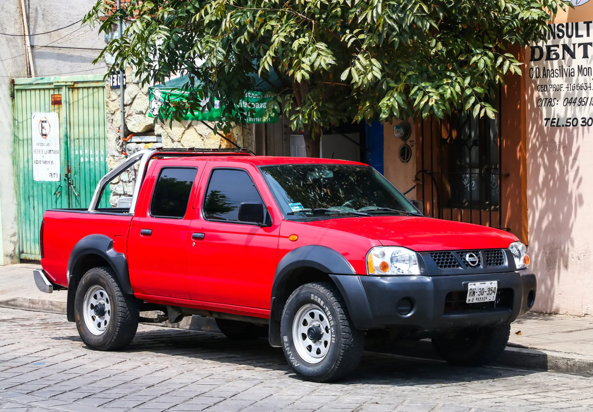 2013 Red pickup truck Nissan Frontier in the city street.