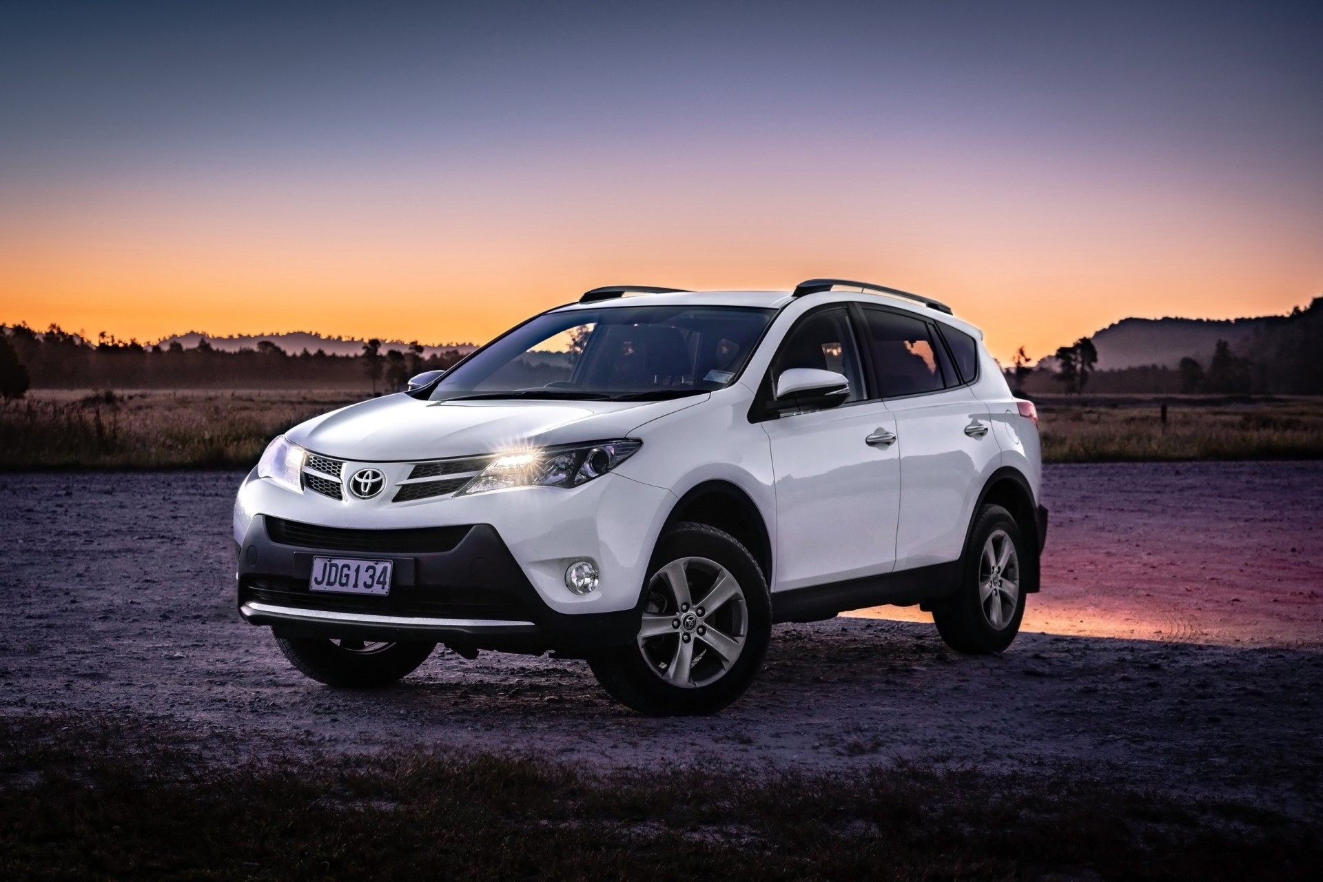2013 White Toyota RAV4
against a sunset background