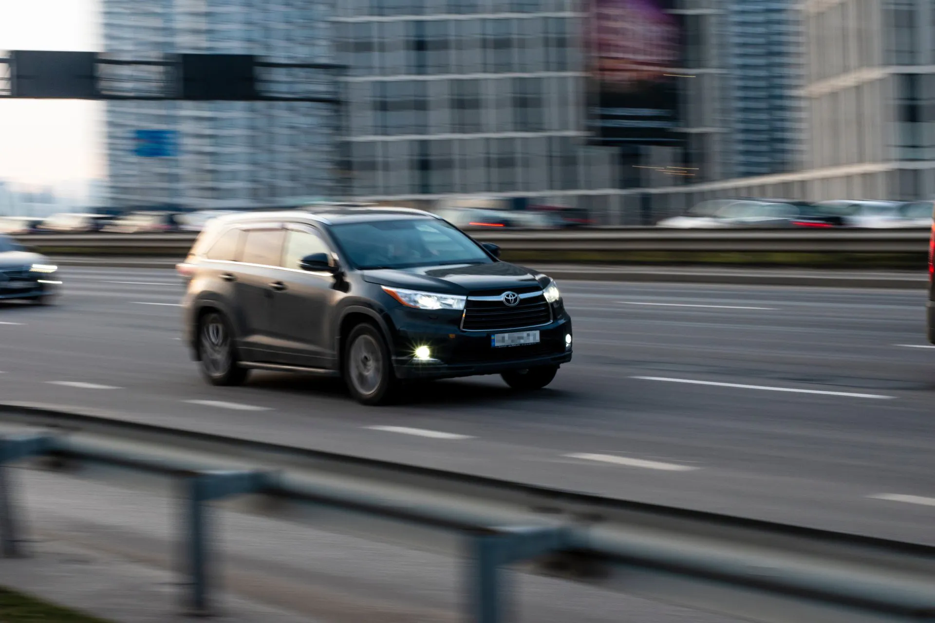 Black Toyota Highlander car moving on the street.