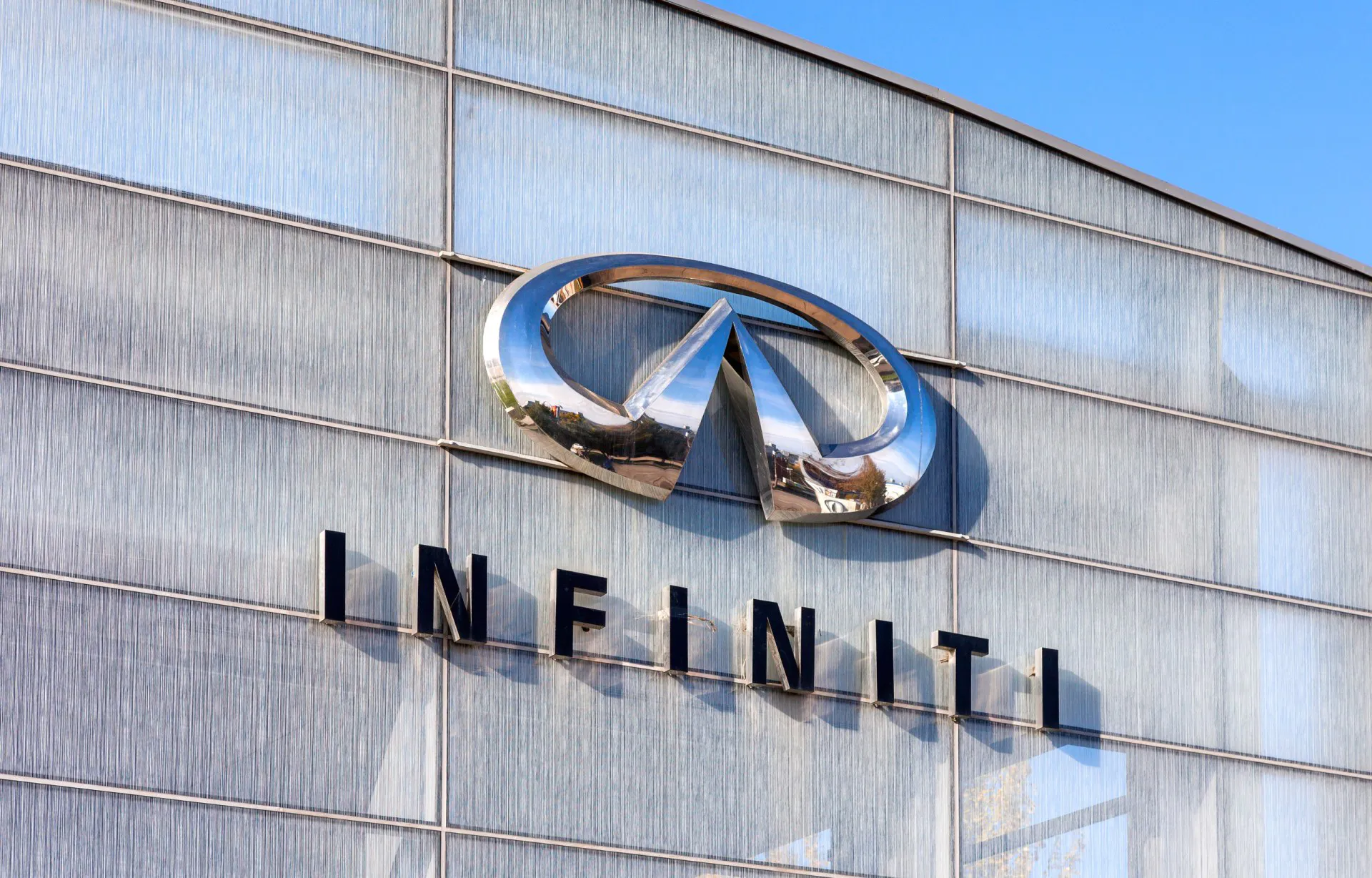 The emblem INFINITI on blue sky background.