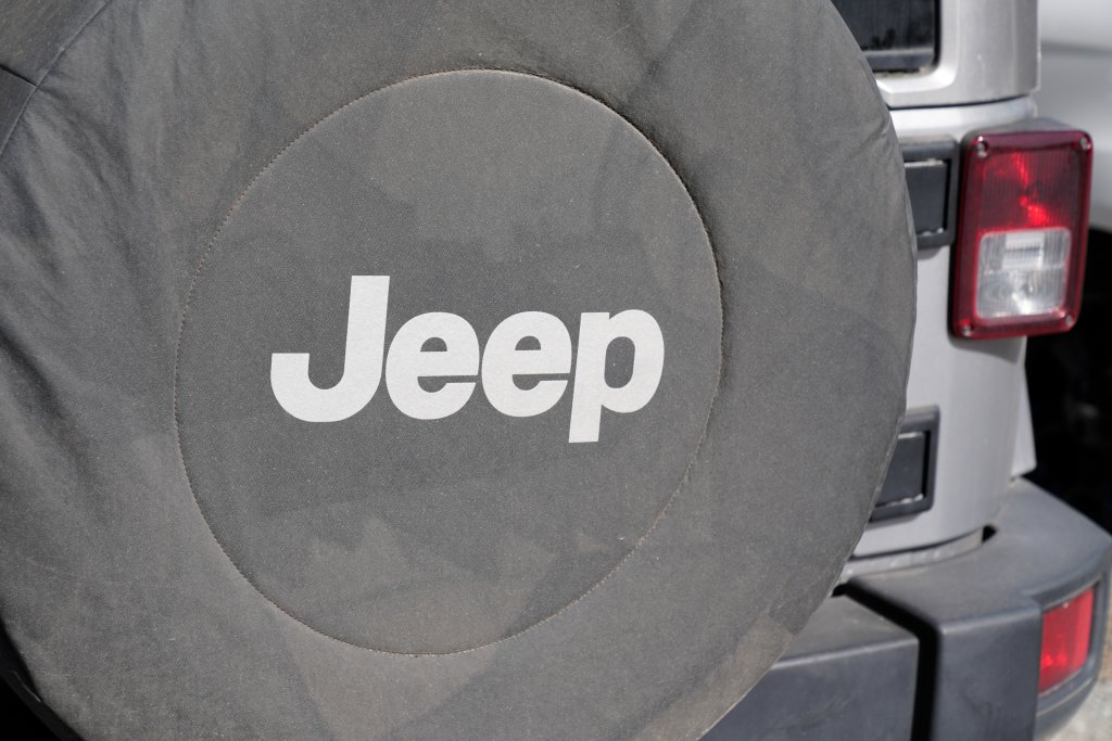 Jeep text sign and brand logo on spare wheel protection in American automobiles sport utility off-road vehicles