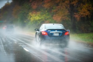 Nissan Maxima car on highway road traffic during heavy rain in autumn fall season