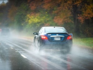 Nissan Maxima car on highway road traffic during heavy rain in autumn fall season