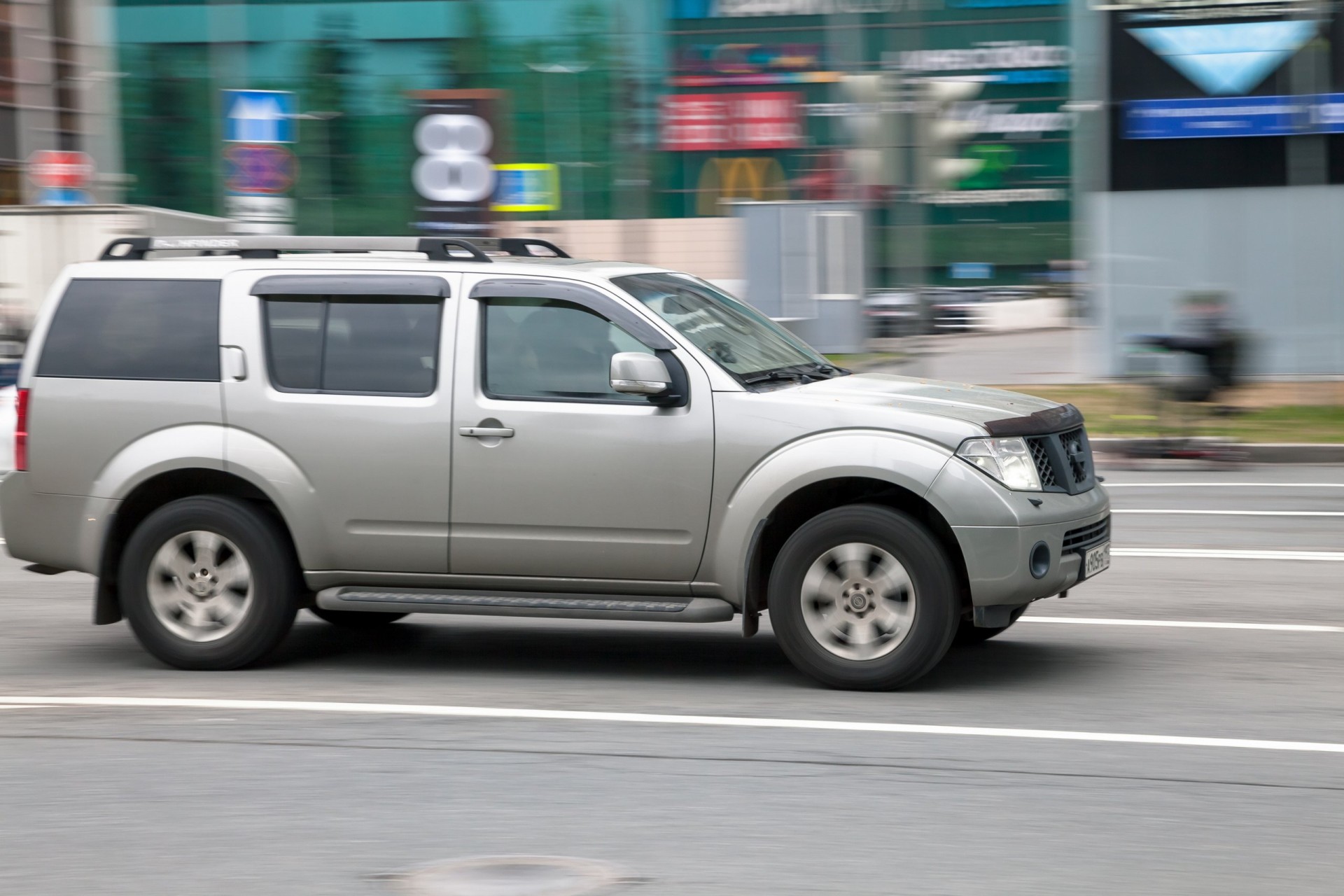Side view of Nissan Pathfinder in motion, moving on the street