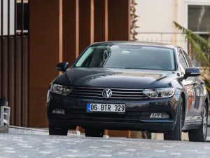 Black Volkswagen Passat is parked on the street on an autumn day