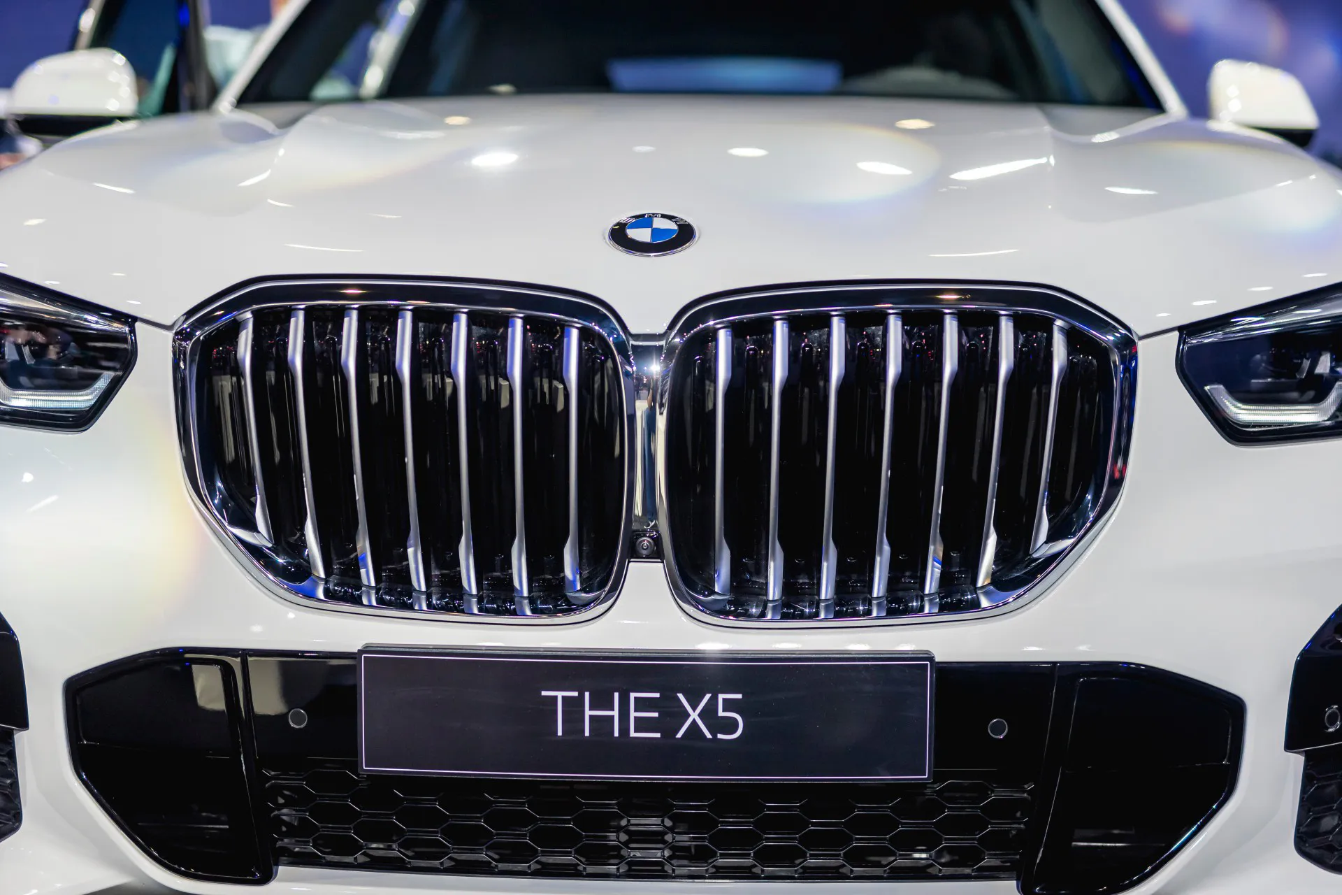 The iconic kidney grille of the 2023 BMW X5 on display at a motor show