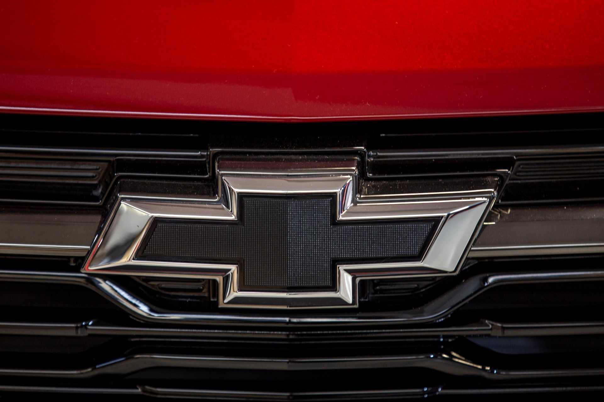 Close up of the Chevrolet car brand logo on dark and red background