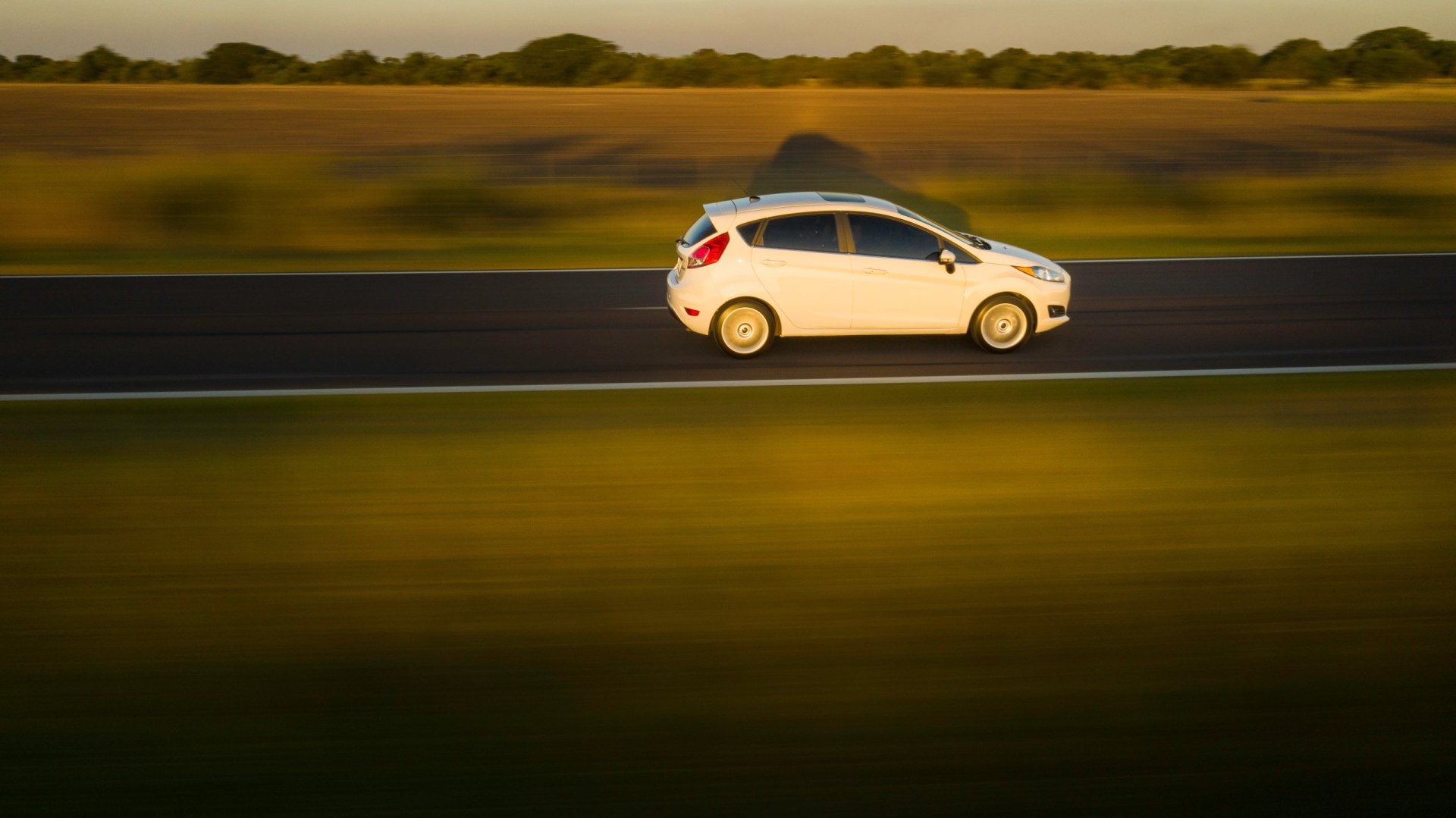 2016 Ford Fiesta Panning photography of a car on the road. Sunset background. Drone shot