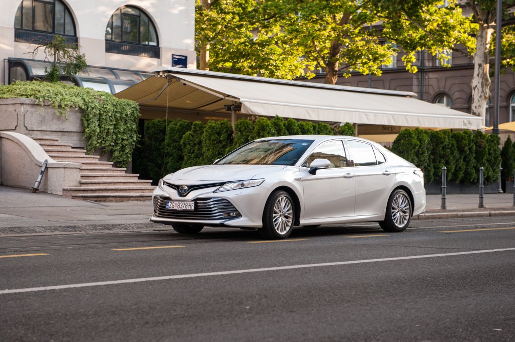 New Toyota Camry in white colour. Luxury business limousine cruising the streets.