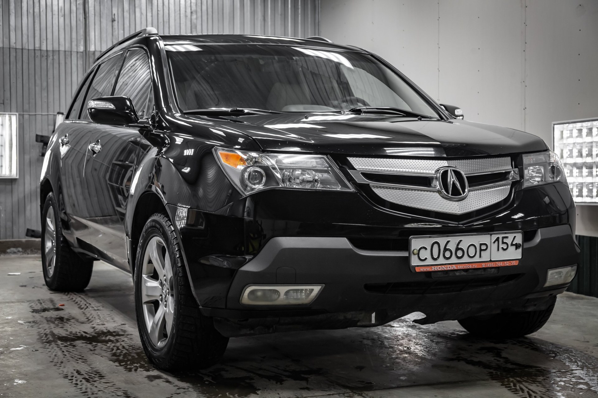 2009 Used Acura MDX black color with headlights standing in the light service box of the detailing workshop