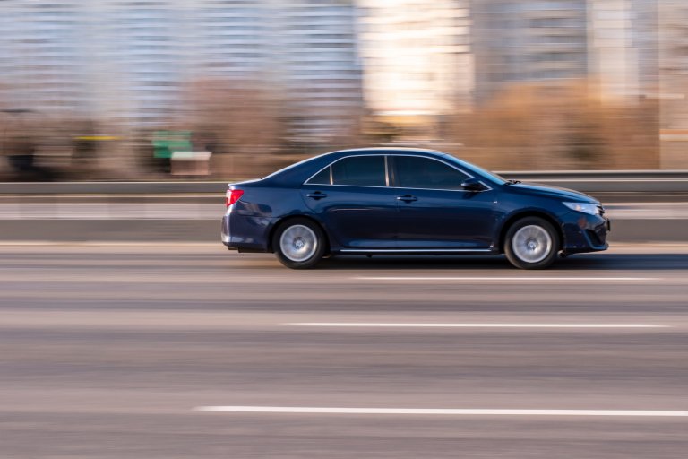 Blue Toyota Camry car moving on the street