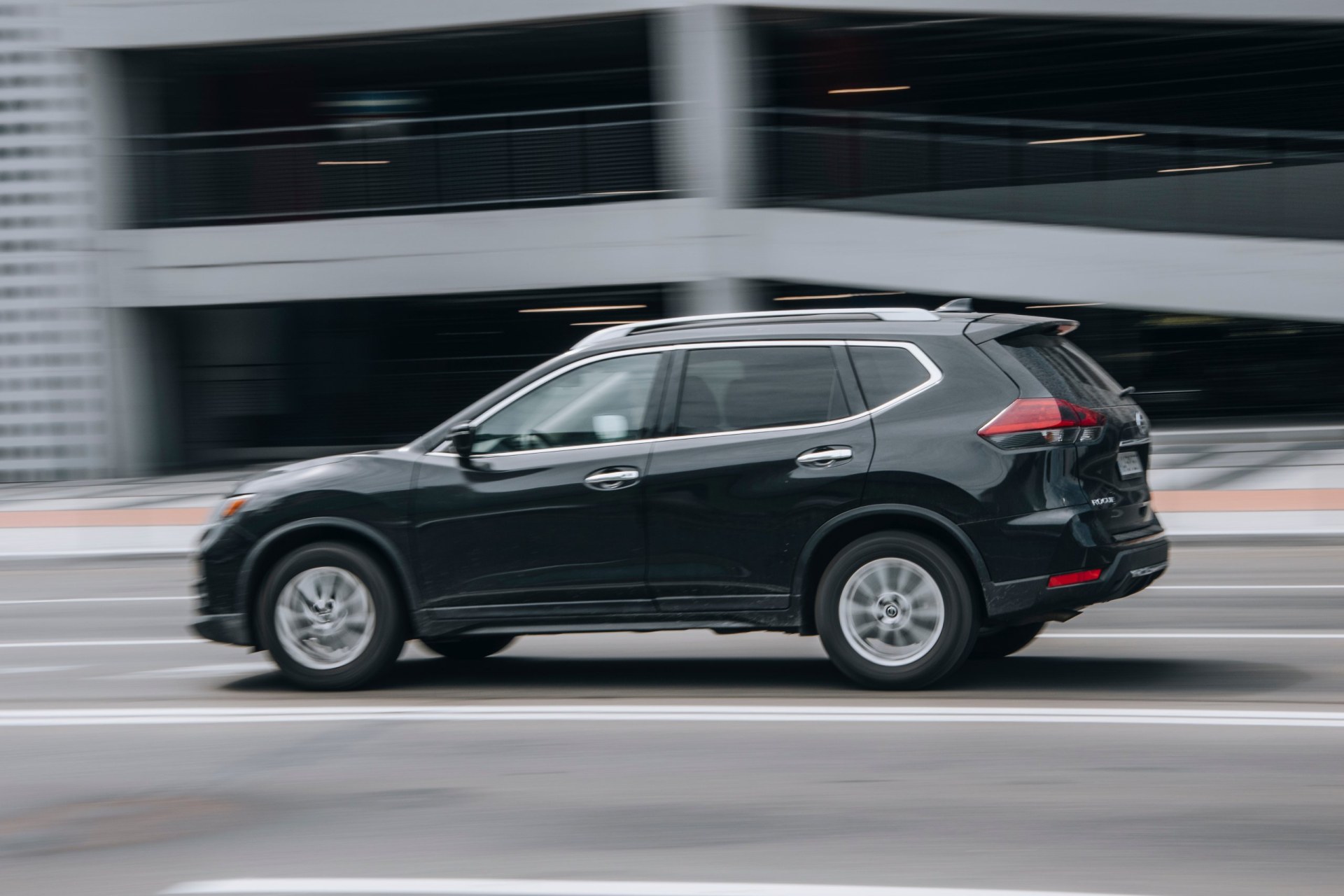 Black 2014 Nissan Rogue car moving on the street