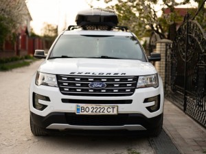 Ford Explorer family car with roof rack Thule Motion XXL box parked roadside