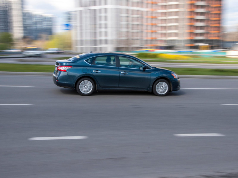 Blue Nissan Sentra car moving on the street.