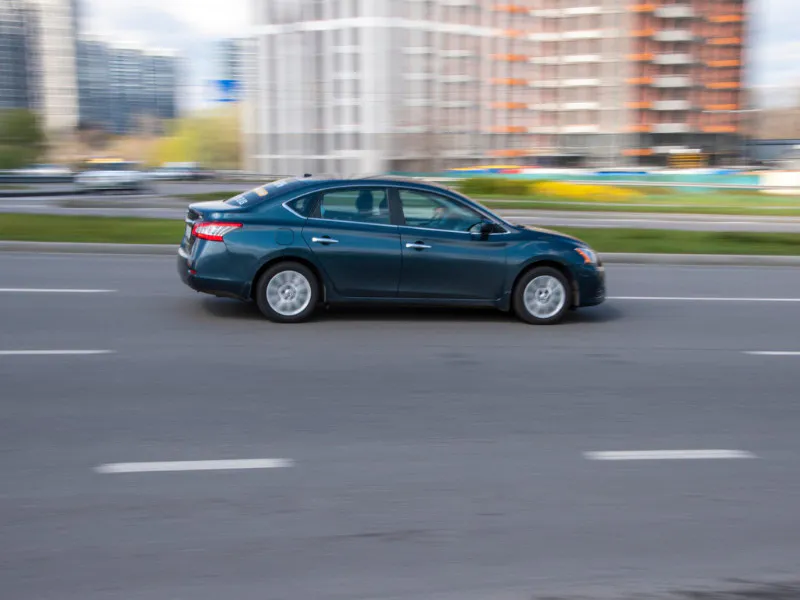Blue Nissan Sentra car moving on the street.
