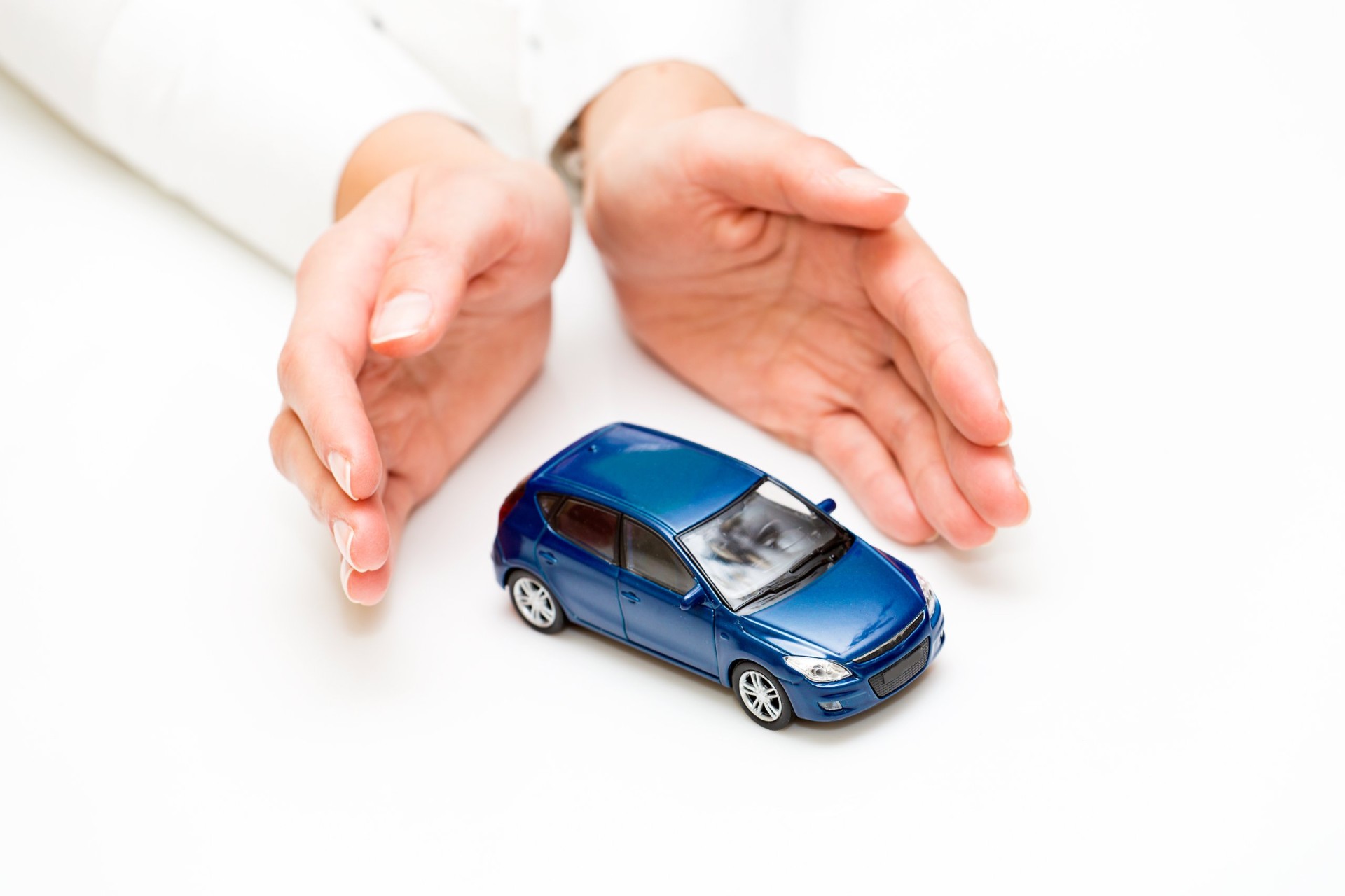 Protection of car. Business concept. Two hands and a blue car