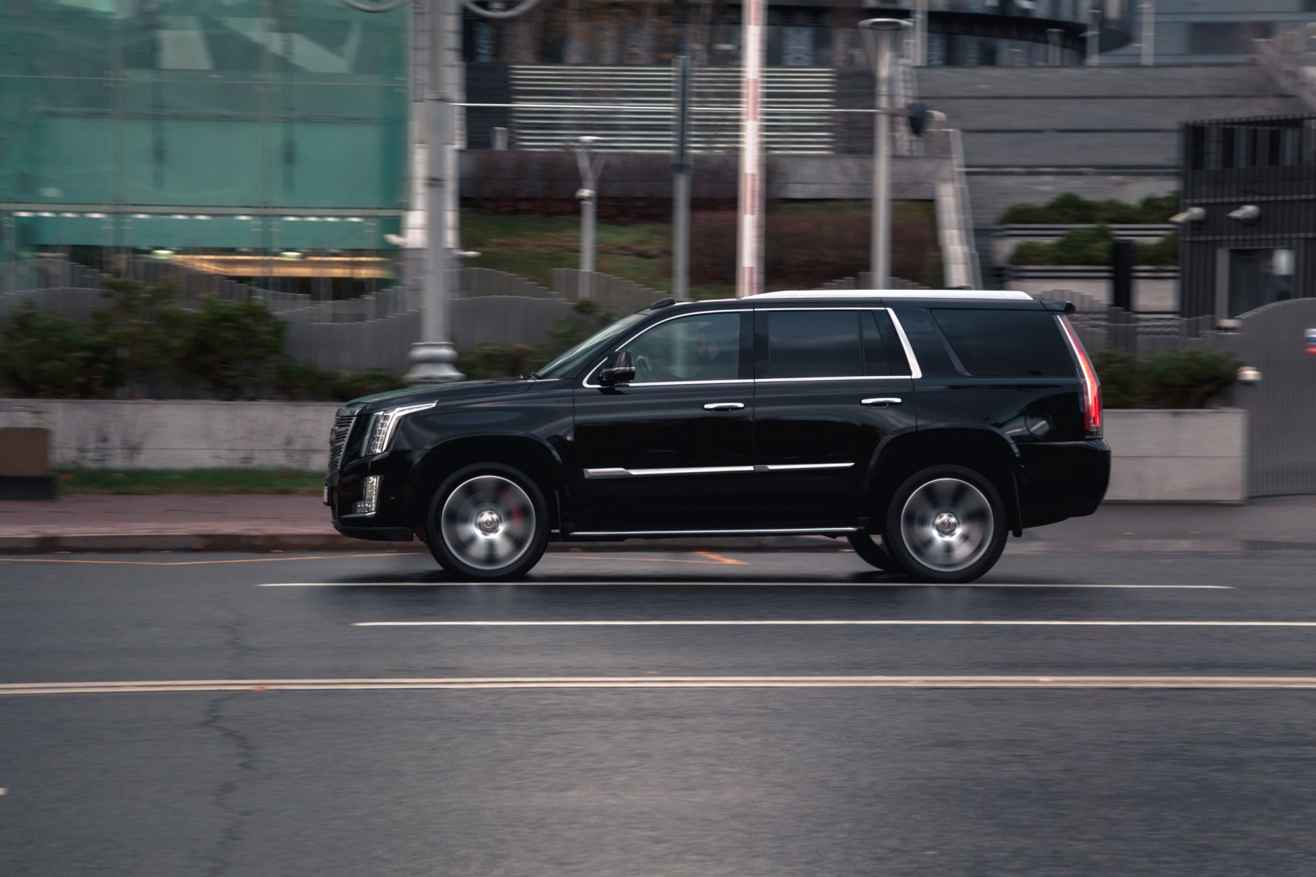 Fast moving Cadillac Escalade on the city road. Fast motion with blurred background.