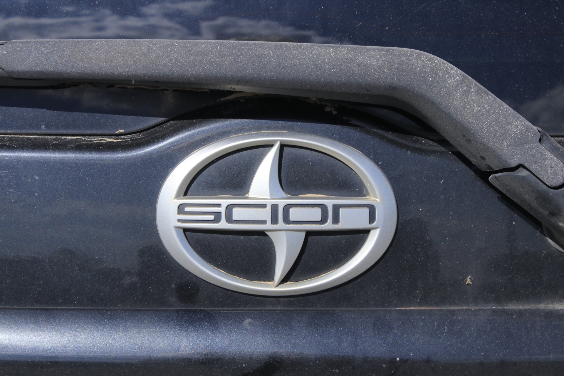 Closeup of SCION emblem on a trunk outdoor,