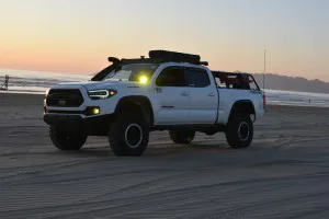 Toyota Tacoma parked at the beach at soft sunset