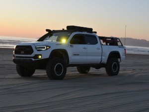 Toyota Tacoma parked at the beach at soft sunset