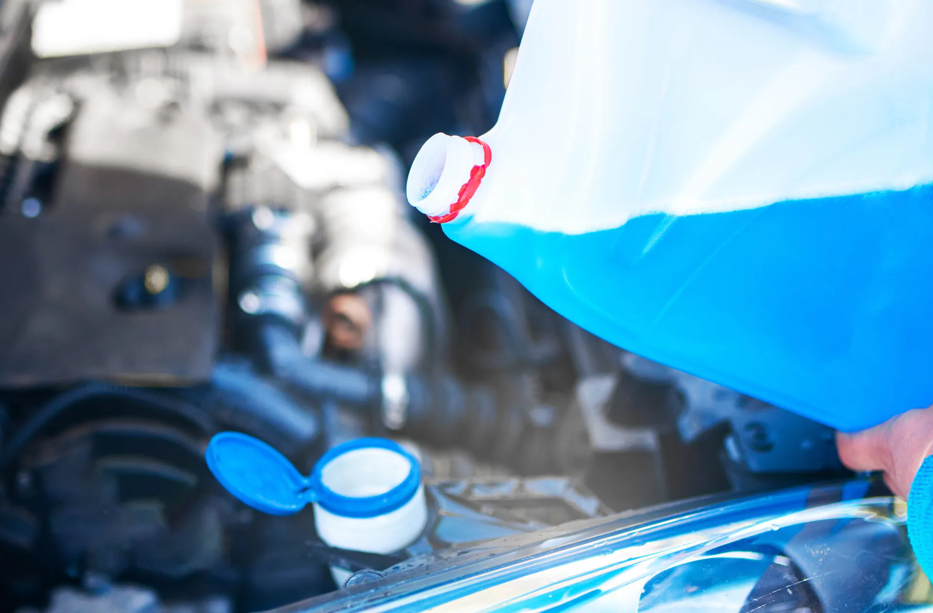 Pouring antifreeze to the car. Filling a windshield washer tank with an antifreeze